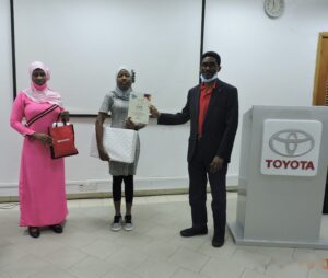 Mr. B. Onafowokan, winner 1st Position 12-15 years category Mariam Ayolola-Omolara Kaka holding her certificate and laptop prize while mum holds other Toyota Corporate gifts
